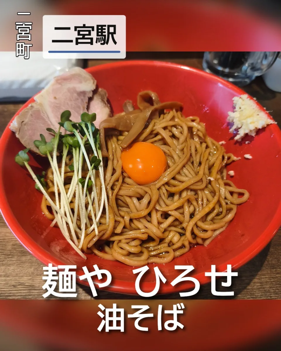 麺や ひろせの油そば。中央に卵黄がのった太麺とチャーシュー、カイワレ、メンマ、刻みニンニクが盛り付けられた一杯